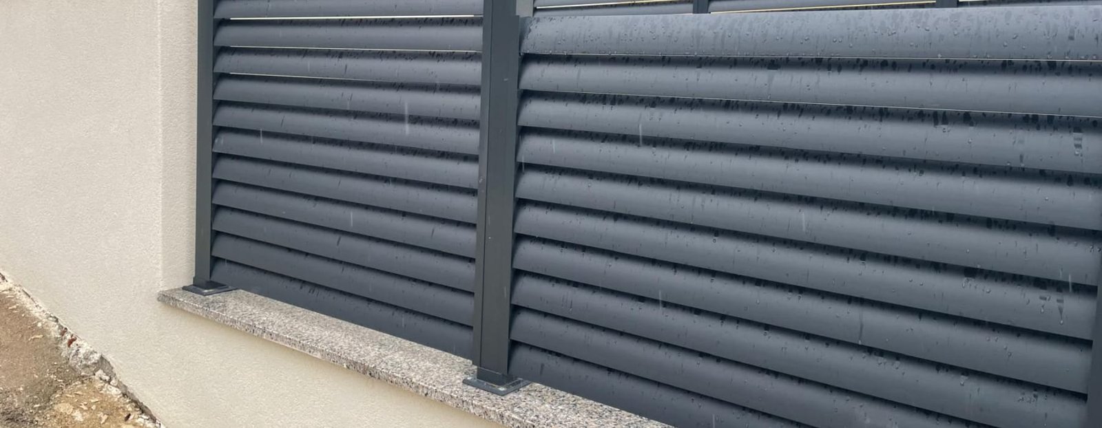 Kapljice kiše na inox ogradi — kiša ispire sol koja bi inače ostala na metalu